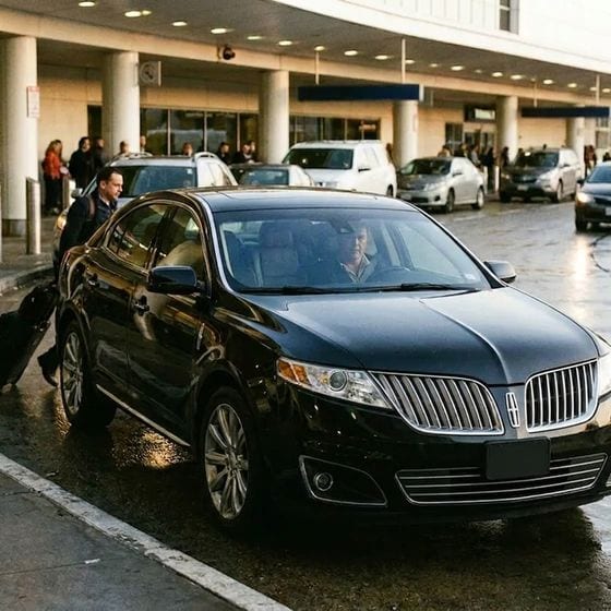 Black Lincoln sedan at airport curbside pickup